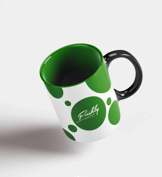 White mug with green circles, a green interior and the Freshly logo